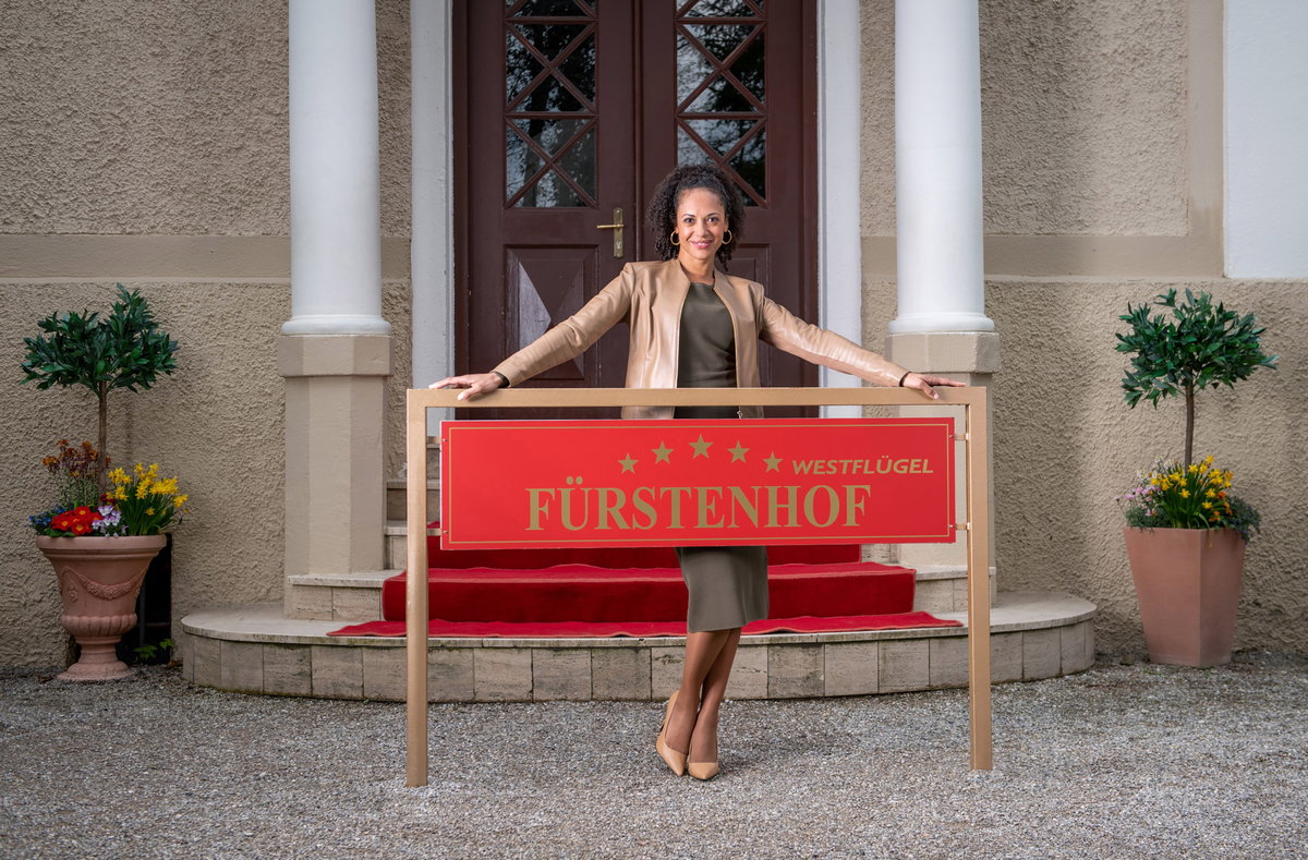 Sturm der Liebe Nicole Alves steht hinter dem Fürstenhof-Schild