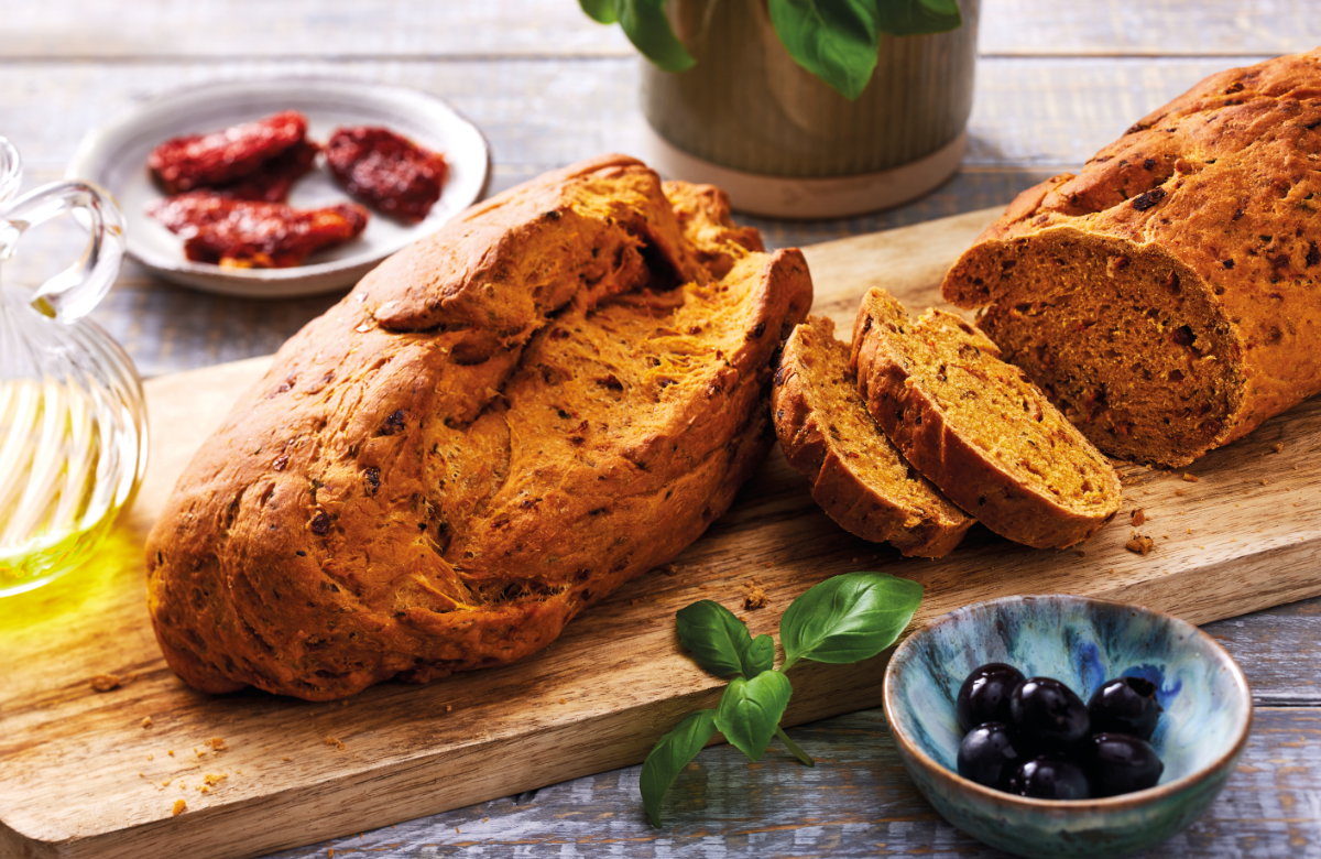 Tomaten-Ciabatta-Brot mit Kräutern auf einem Holzbrett