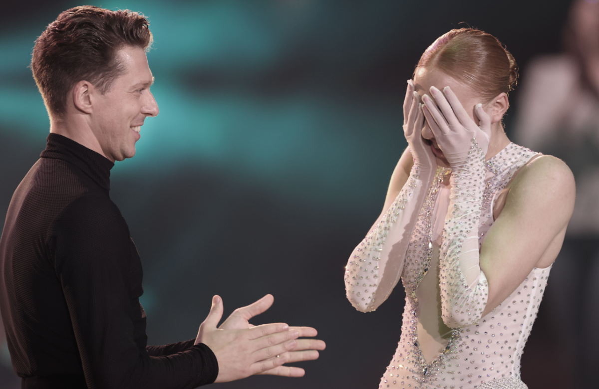 Valentin Lusin lächelt, Anna Ermakova hält sich Hand vors Gesicht