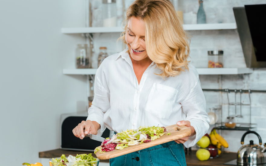 Frau in den Wechseljahren kocht