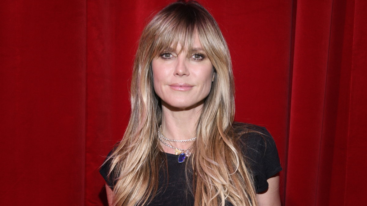 Heidi Klum steht vor einem roten Vorhang