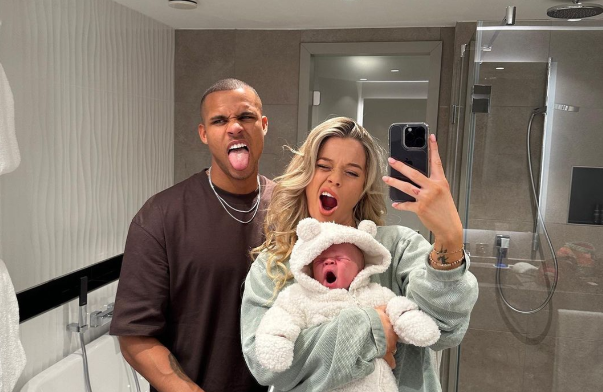 Kevin Njie und Emily Hüffer müde mit ihrem Baby vorm Spiegel