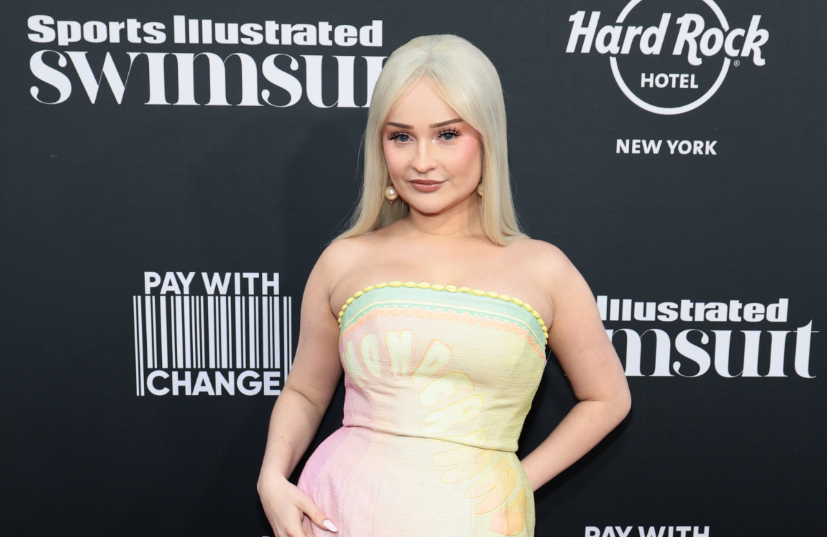 Kim Petras posiert vor einer dunklen Wand