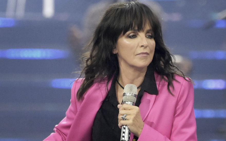 Nena in einem pinken Blazer und mit Mikro in der Hand läuft über die Bühne