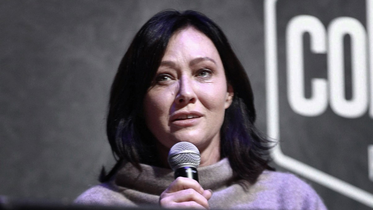 Shannen Doherty hält Mikrofon in der Hand und sieht traurig aus