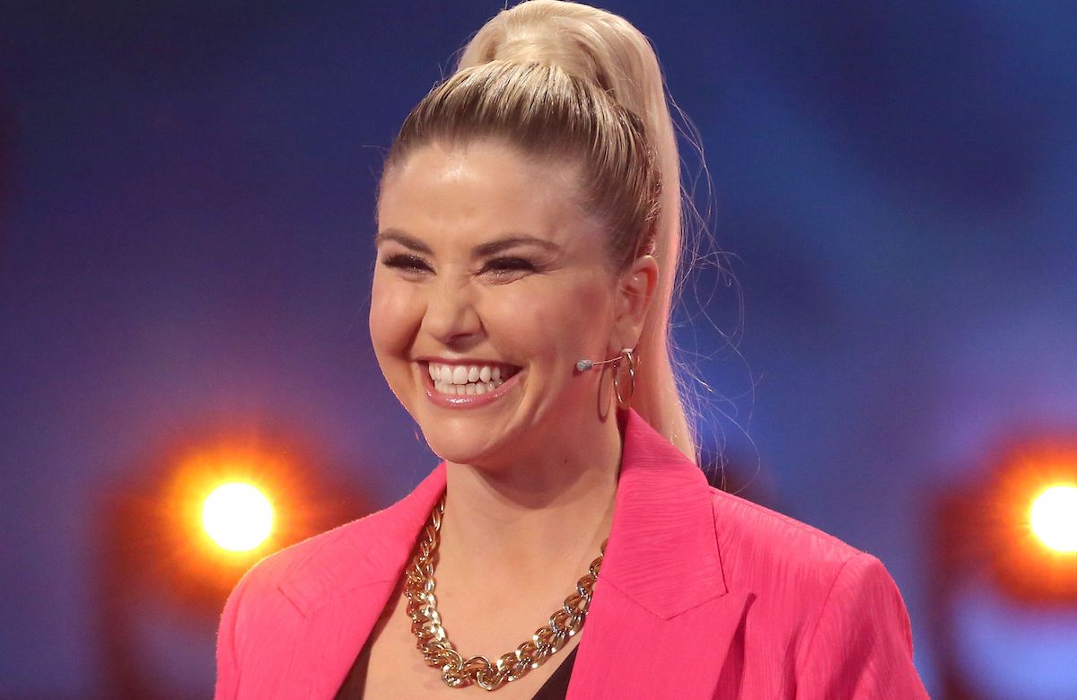 Beatrice Egli lächelt im pinken Anzug