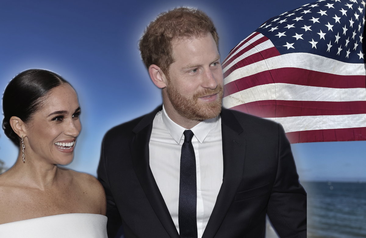 Herzogin Meghan und Prinz Harry vor USA-Flagge, beide lächeln.