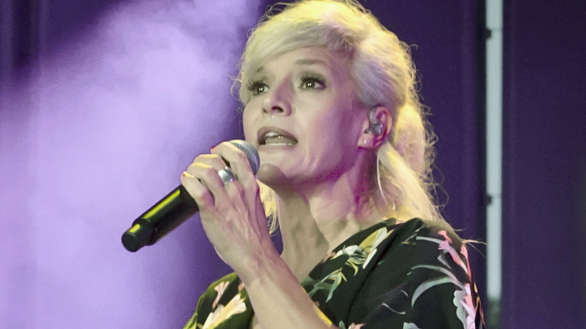 Ina Müller singt ins Mikrofon auf der Bühne