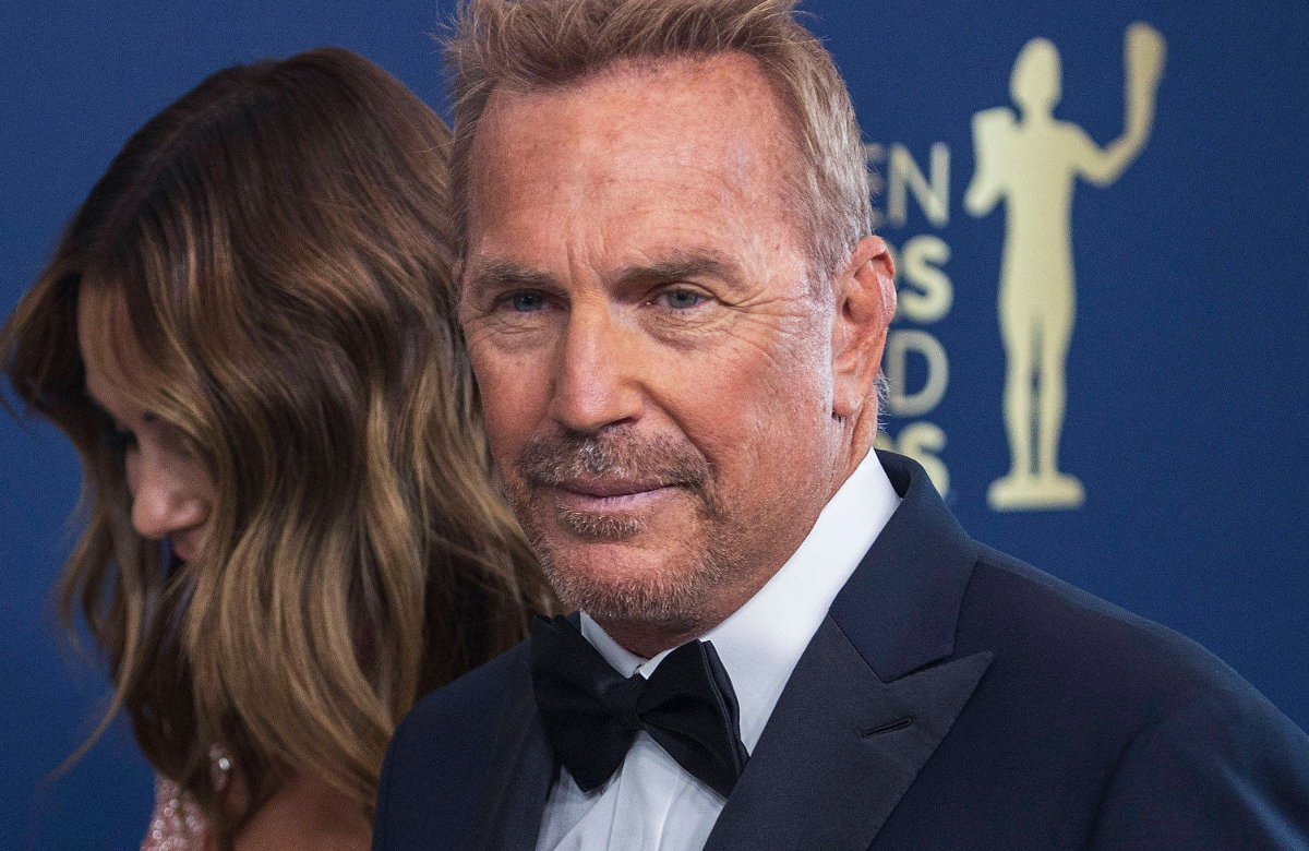 Kevin Costner guckt ernst, lächelt leicht