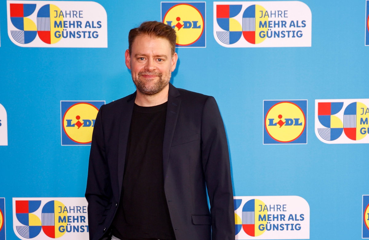 Max Giermann lächelt bei Lidl-Event im Anzug