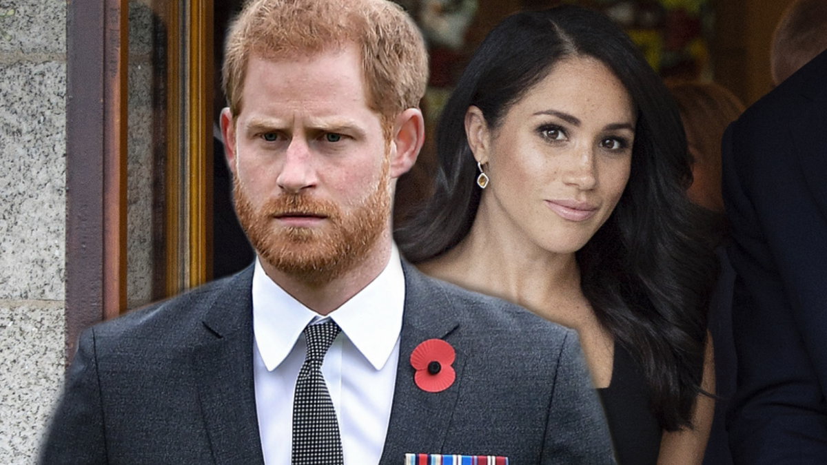 Prinz Harry sieht ernst aus, Herzogin Meghan lächelt im Hintergrund