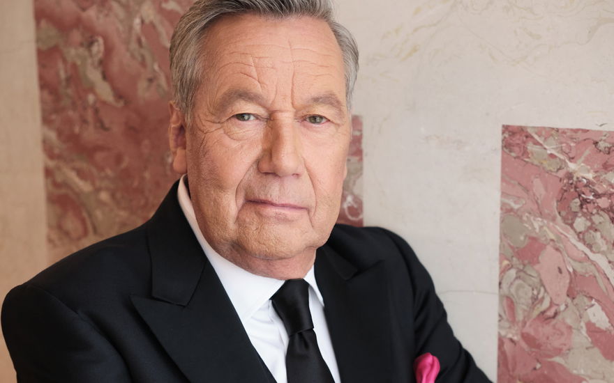 Roland Kaiser steht mit verschränkten Armen an der Wand
