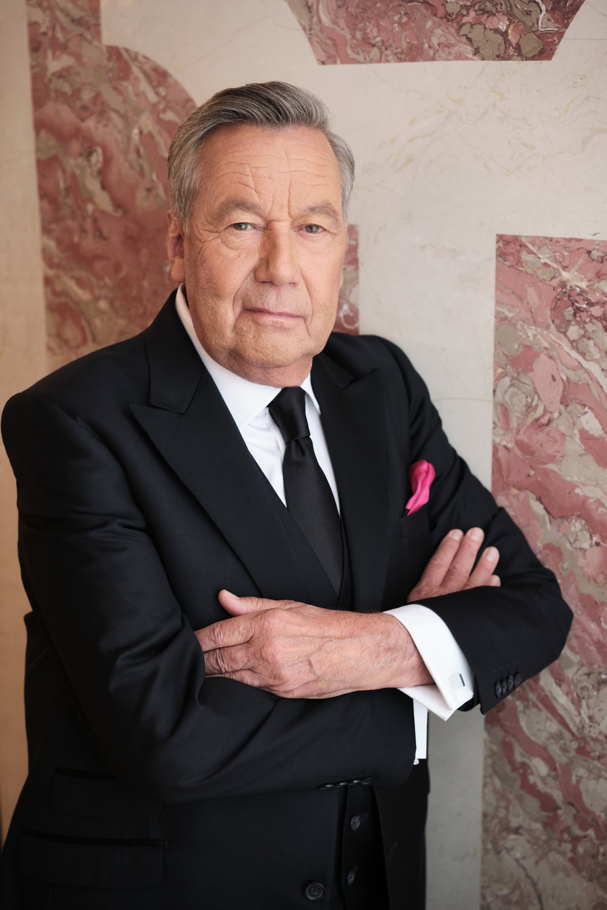 Roland Kaiser steht mit verschränkten Armen an der Wand