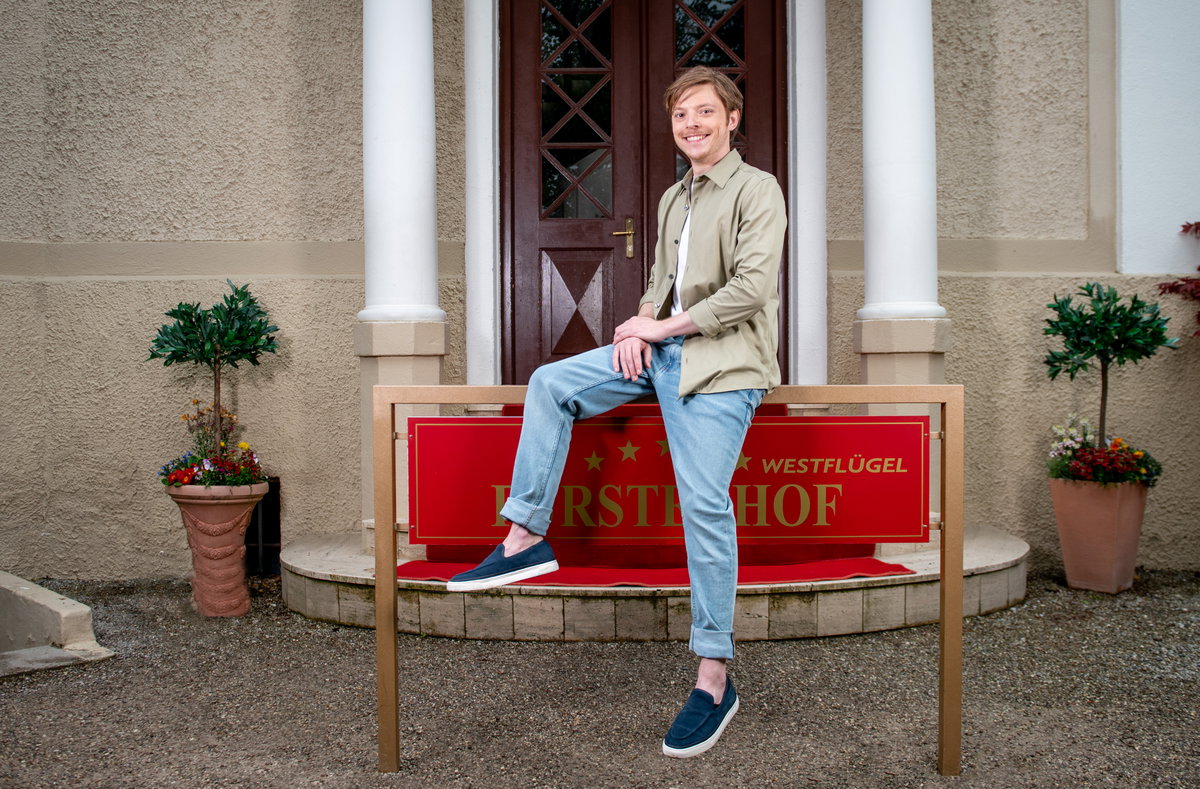 Sturm der Liebe Lukas Leibe sitzt auf Fürstenhof-Schild