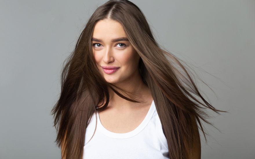 Frau mit dunklen Haaren freut sich über Volumen