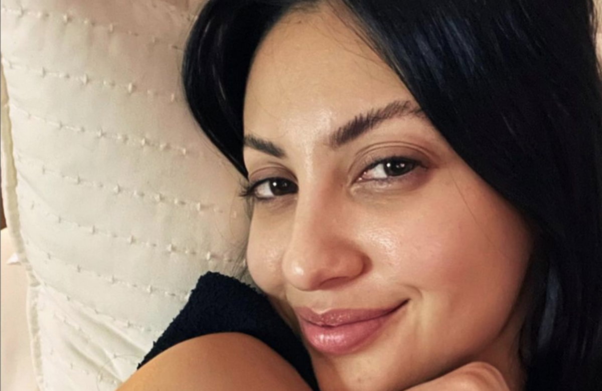 Francia Raisa lächelt ungeschminkt im Bett auf Instagram-Selfie