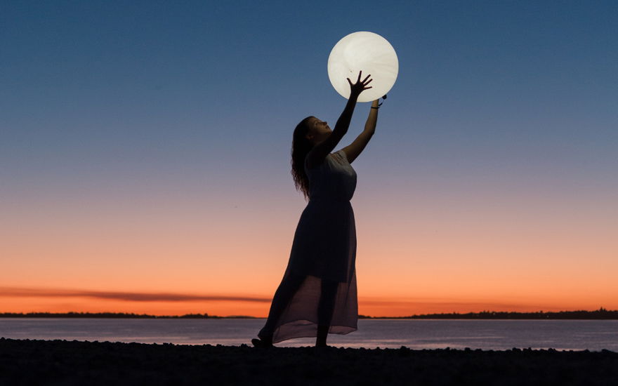 Frau hält Mond in den Händen
