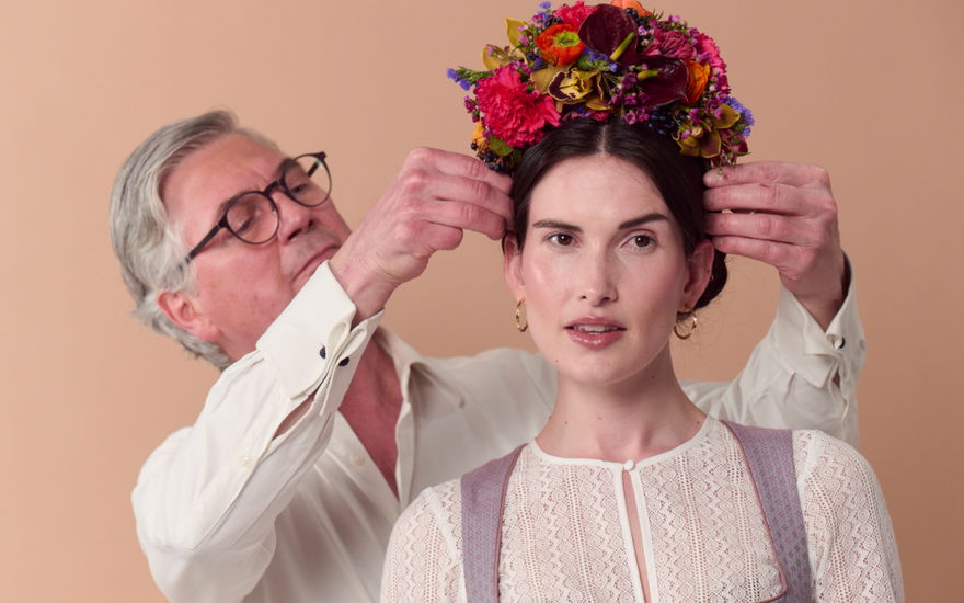 Frau bekommt Blumenkranz auf den Kopf gesetzt