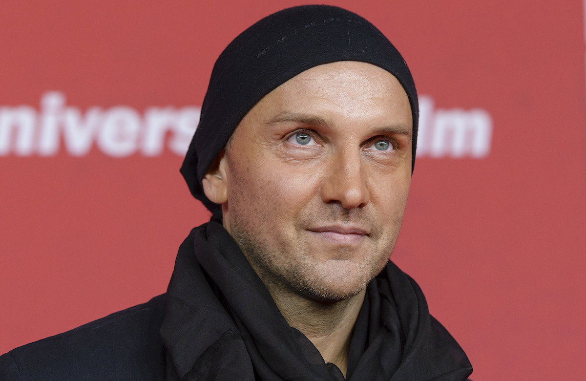 Hubertus Regout mit Mütze vor rotem Hintergrund