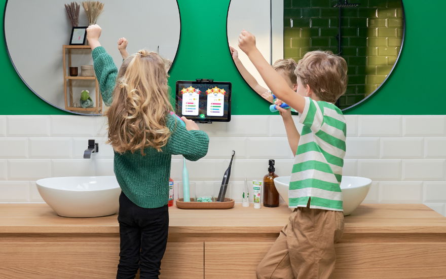 zwei kinder putzen zähne mit playbrush und jubeln
