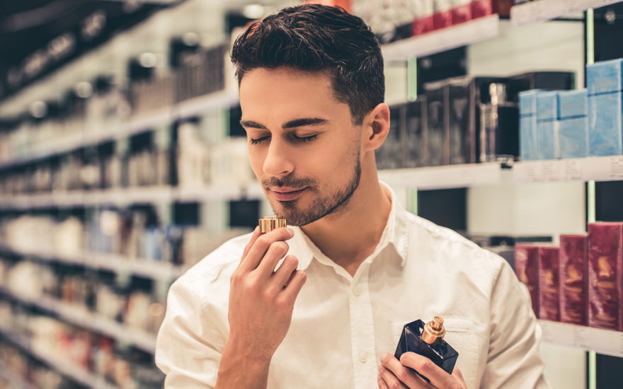 Mann riecht an neuem Parfum