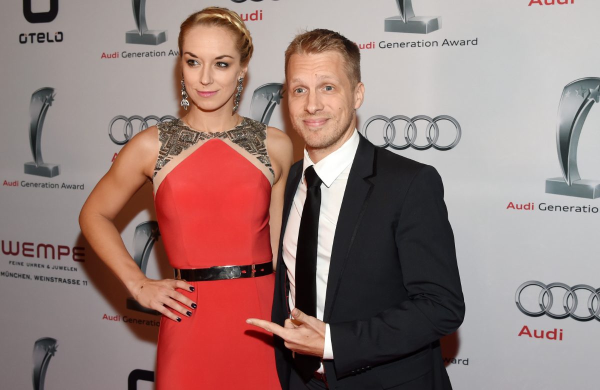 Sabine Lisicki und Oliver Pocher posieren vor einer weißen Wand