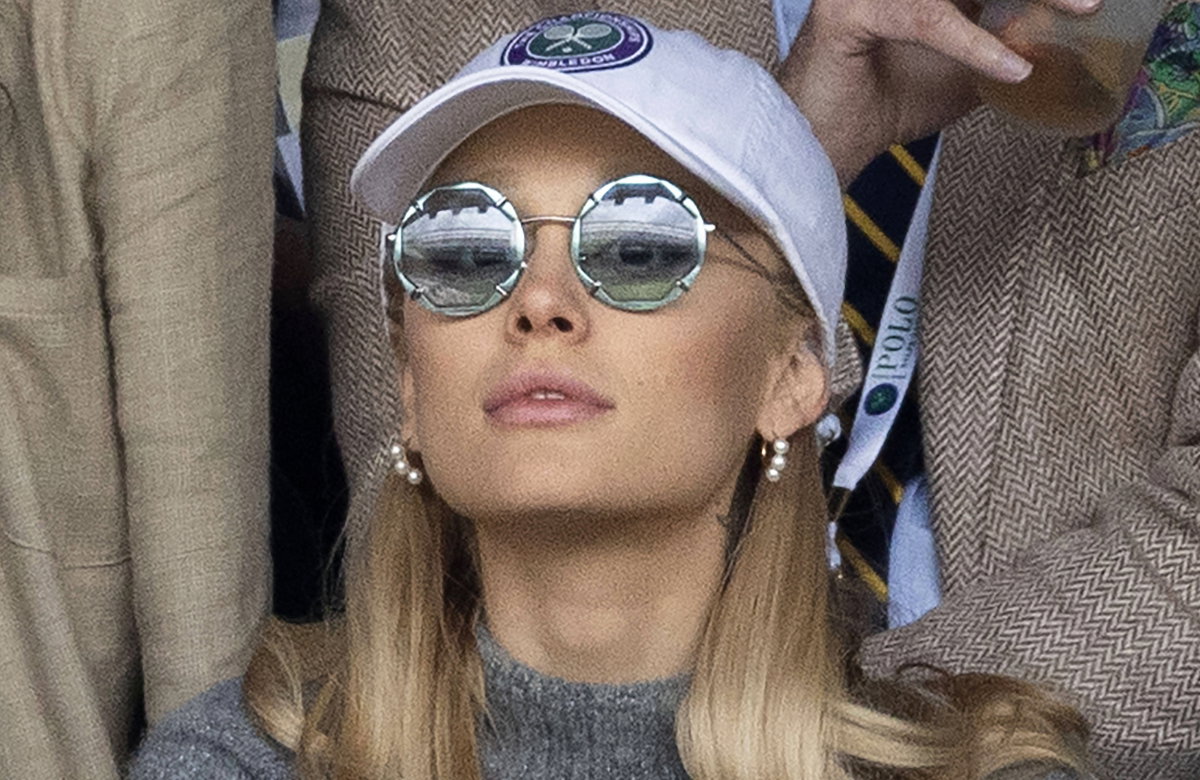 Ariana Grande guckt konzentriert mit Sonnenbrille und Cap beim Wimbledon 2023