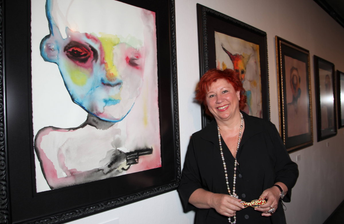 Barbara Salesch lacht bei einer Kunstausstellung vor ihrem Bild "Trainables"