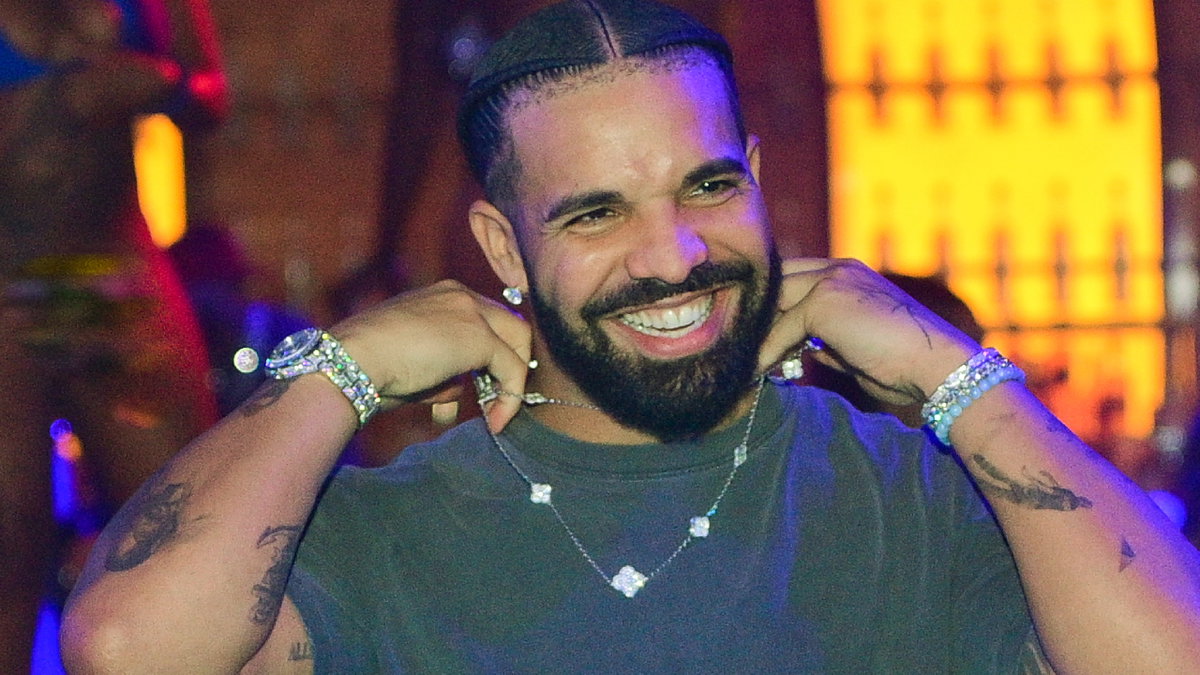 Drake lacht und richtet seine Kette