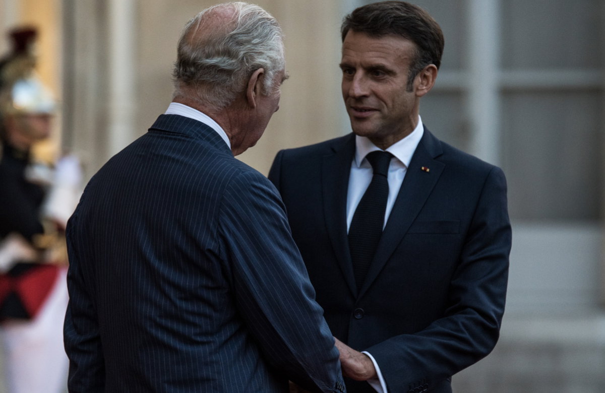 Emmanuel Macron und König Charles III. reichen sich die Hände.