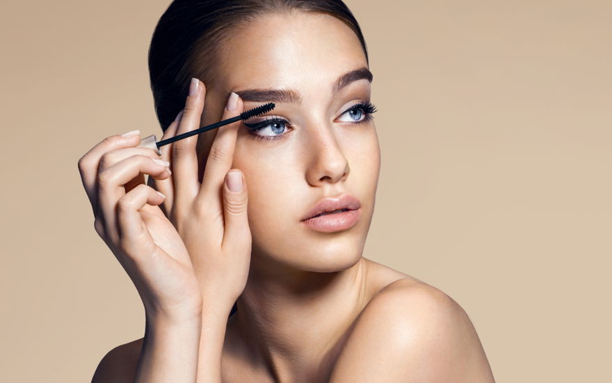 Frau vervielfacht Wimpern mit Mascara