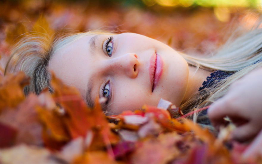 Frau mit perfektem Teint im Herbstlaub
