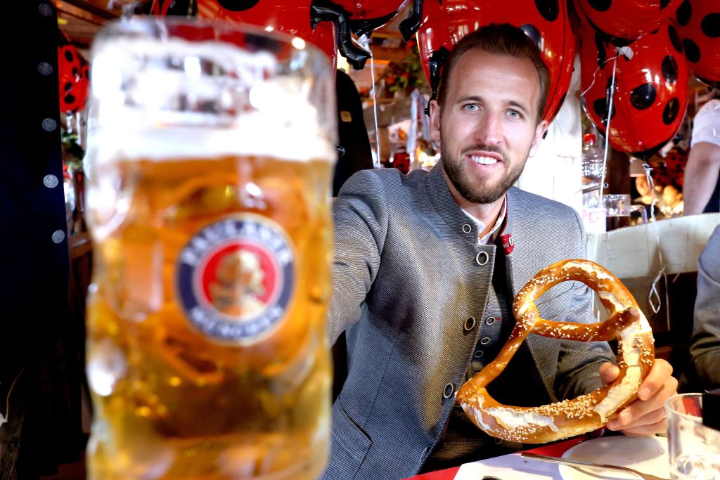Harry Kane vom FC Bayern München posiert mit Maß Bier und Brezen auf dem Oktoberfest 2023