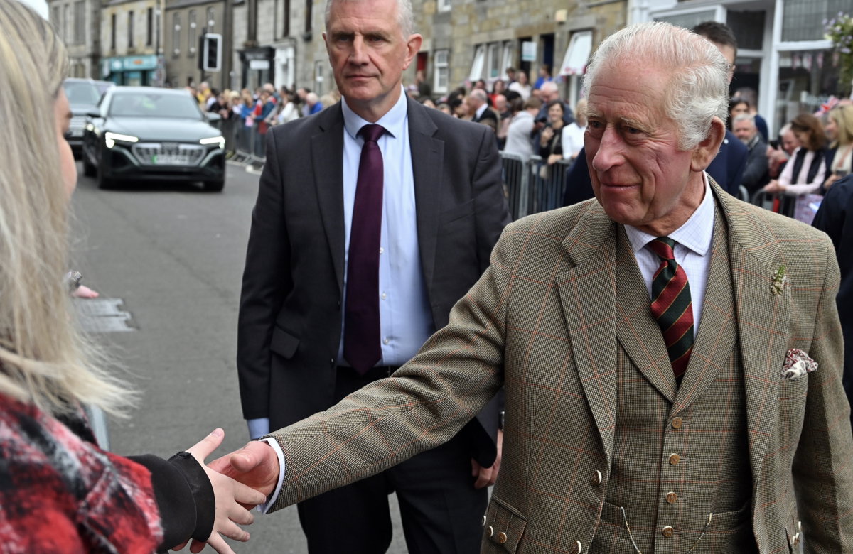 König Charles III. Schottland, er schüttelt einer Frau die Hand.