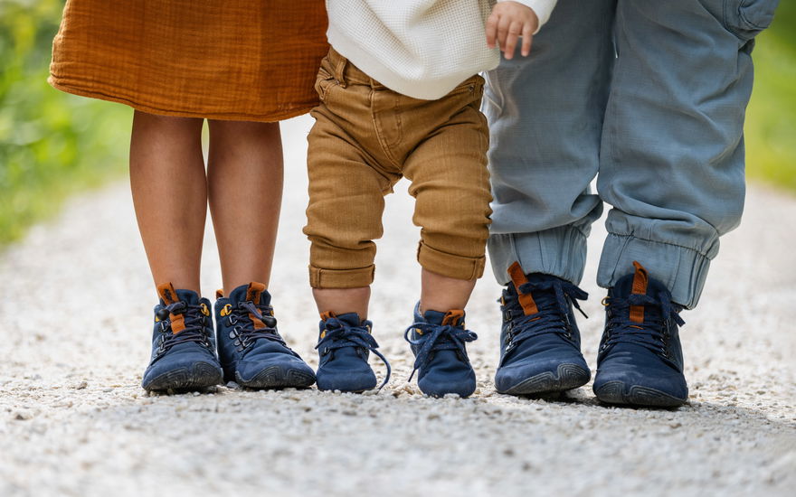 Drei Kinderfüße mit Barfußschuhen von Wildling