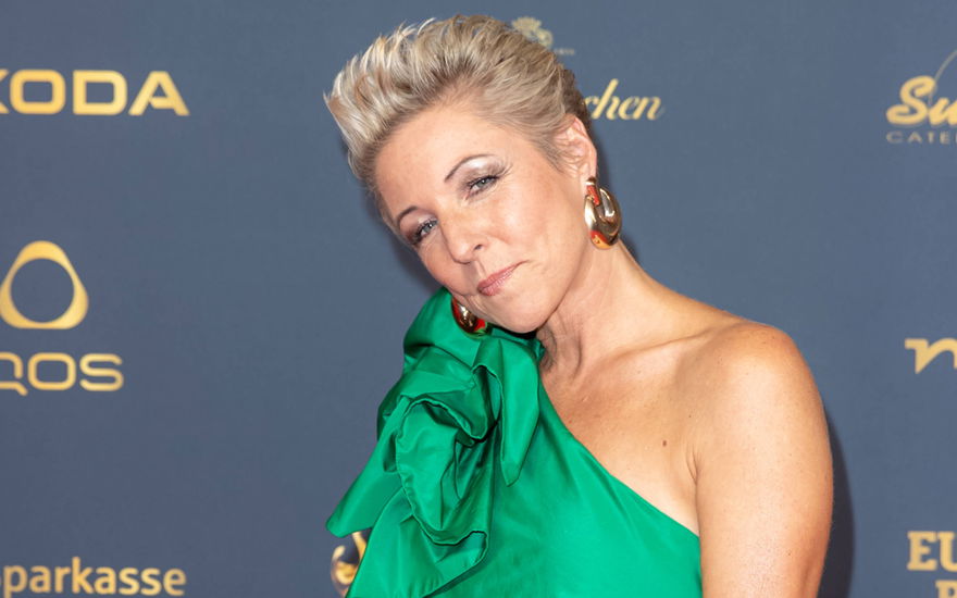Alexandra Hofman guckt ernst im grünen Kleid