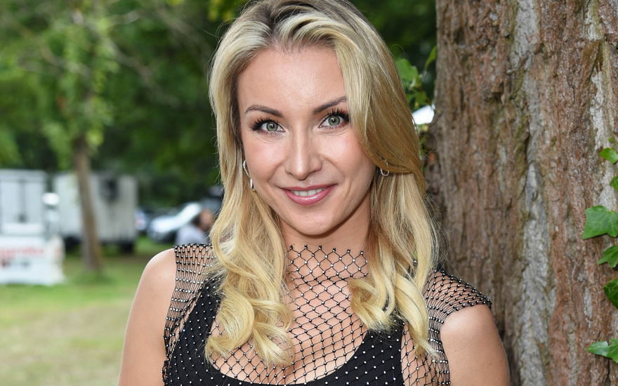 Anna-Carina Woitschack steht lächelnd neben einem Baum