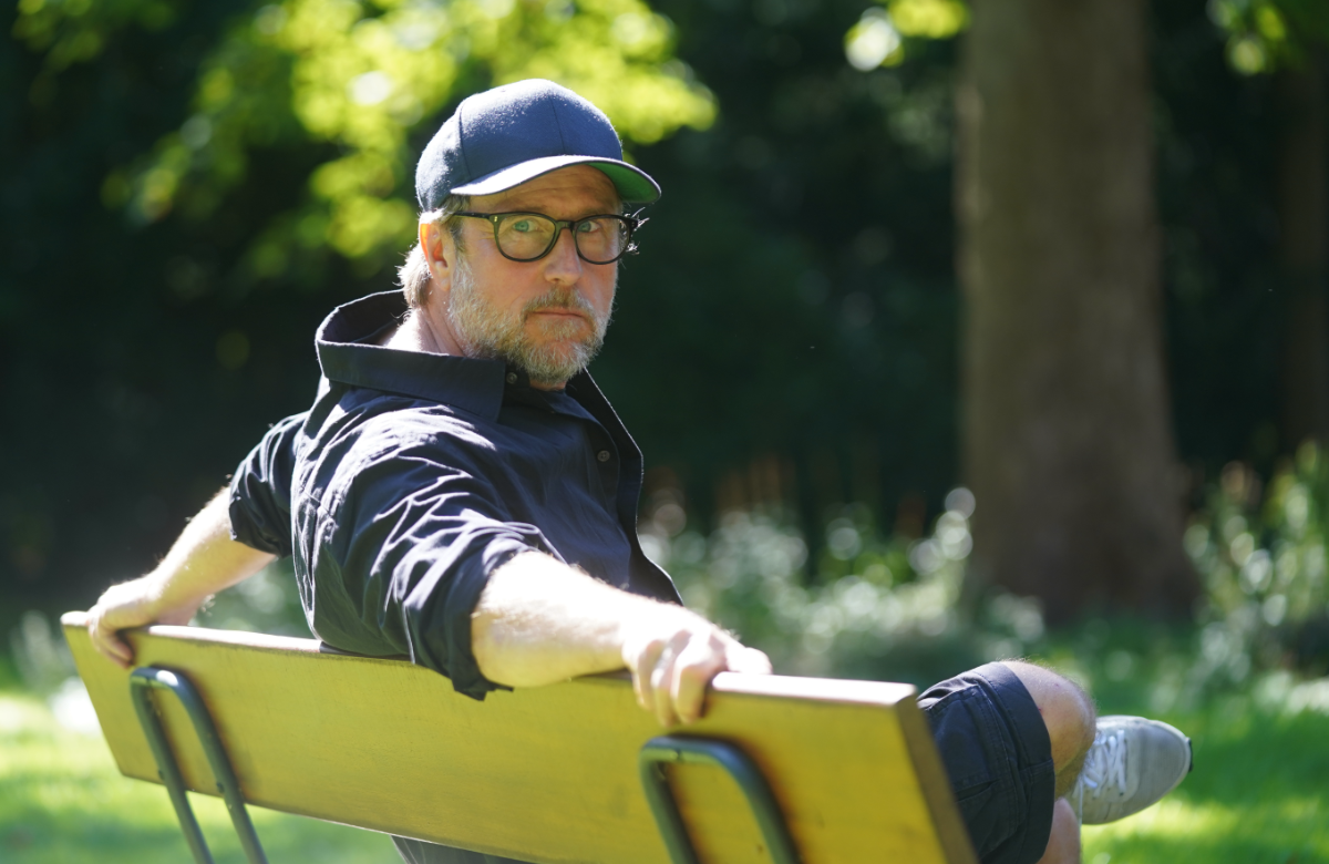Bjarne Mädel als Kriminalhauptkommissar Sörensen auf einer Bank