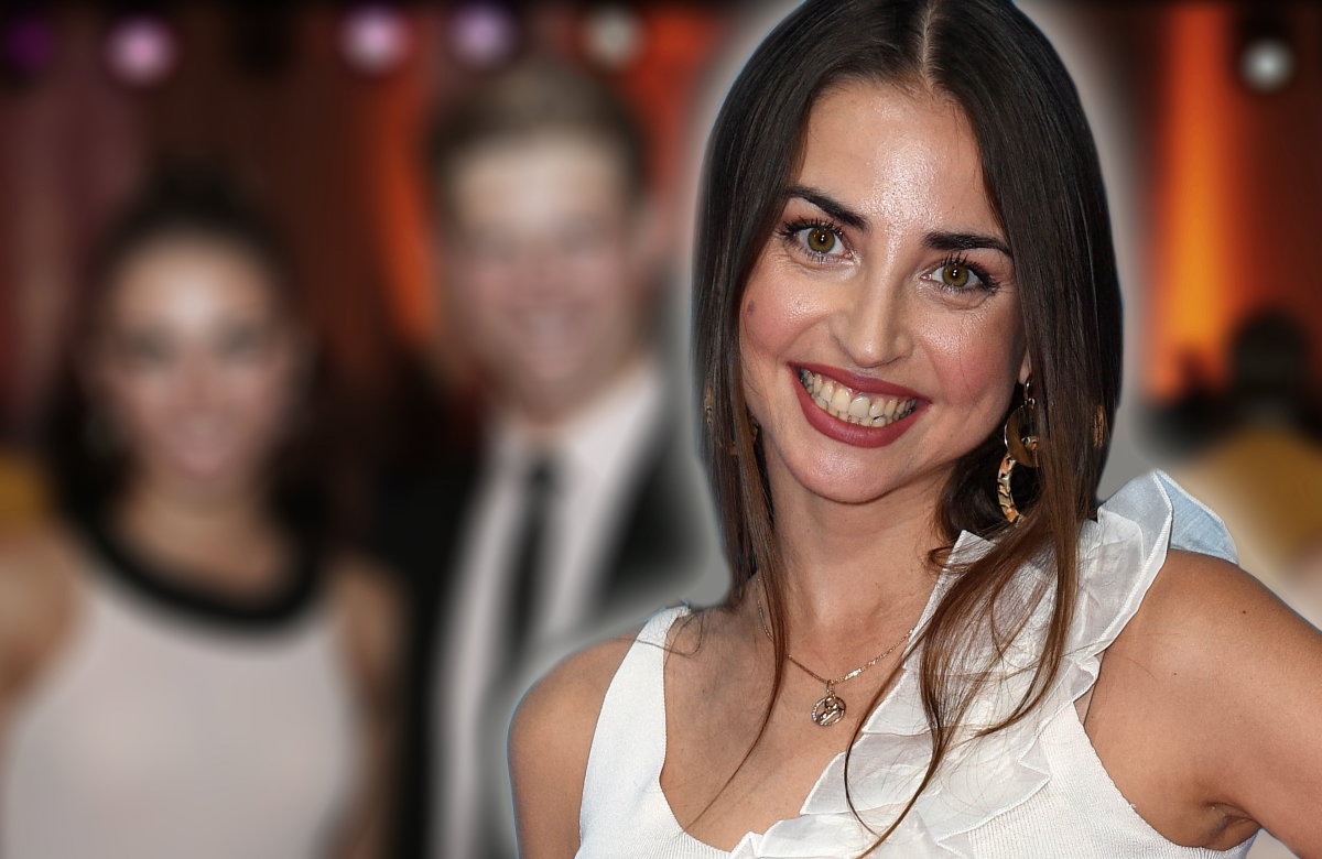 Ekaterina Leonova lächelt, im Hintergrund ein verschwommenes Bild von ihr und Paul Lorenz