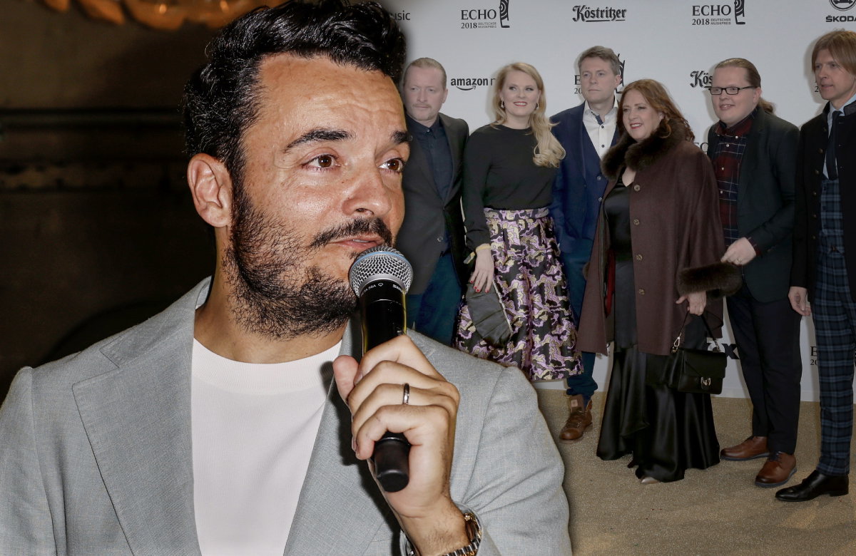Giovanni Zarrella spricht ins Mikrofon, im Hintergrund ein Bild der Kelly Family