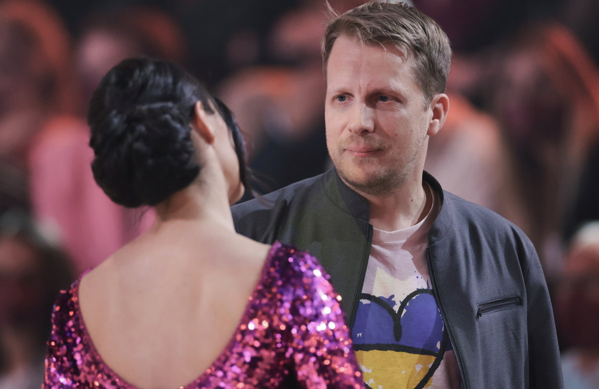 Oliver Pocher steht vor Amira, sie hat den Rücken zur Kamera gedreht, er sieht traurig aus
