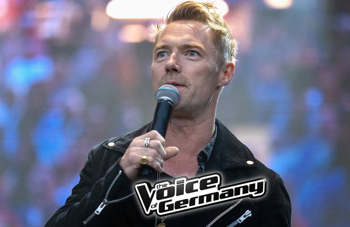 Ronan Keating spricht ins Mikrofon, vor ihm das "The Voice of Germany"-Logo