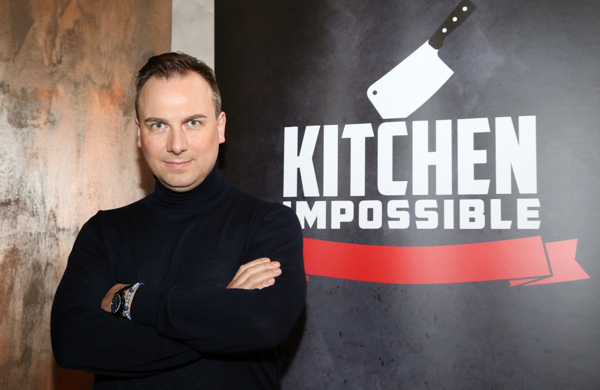 Tim Raue vor einer "Kitchen Impossible"-Wand