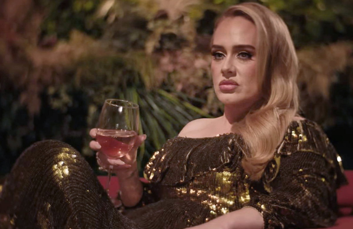 Adele schmollt mit Weinglas in der Hand