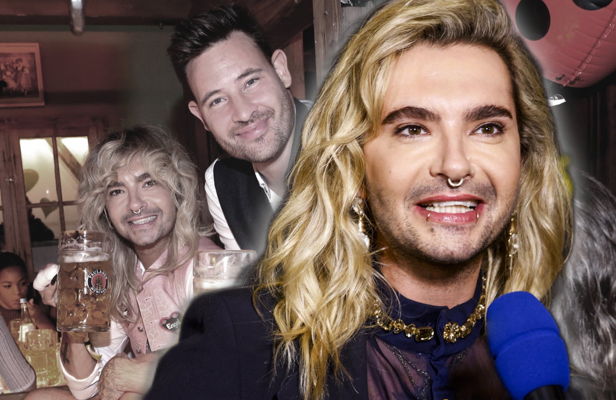 Bill Kaulitz strahlt bei Interview, im Hintergrund ein Bild von ihm und Marc Eggers beim Oktoberfest 2023