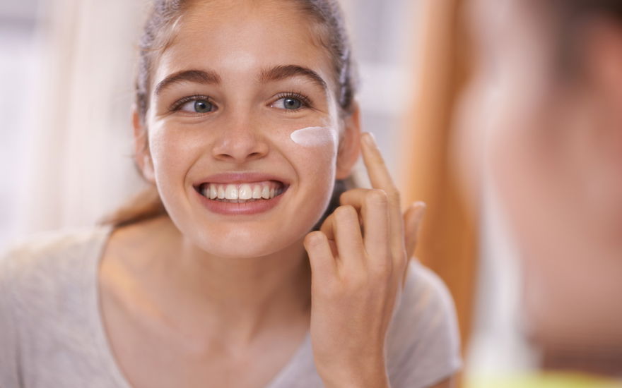 Frau mit Anti-Aging-Creme gegen erste Falten