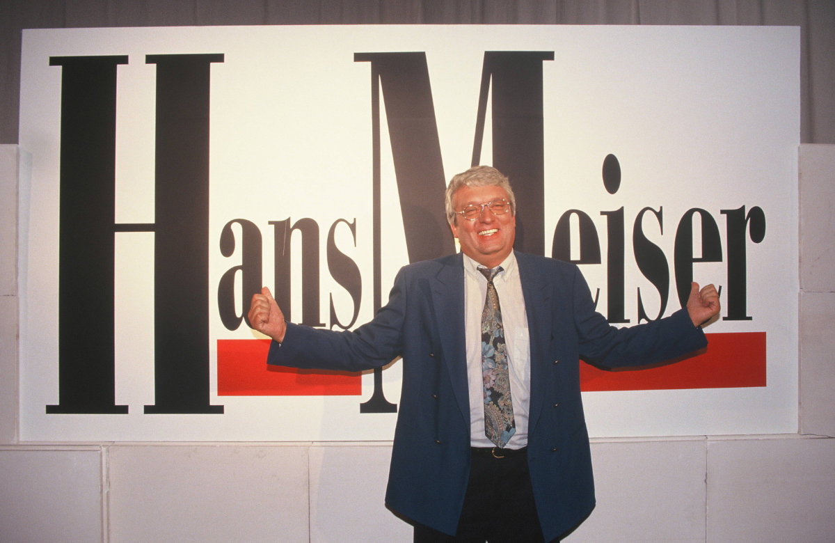 Hans Meiser vor einem Plakat zur Talkshow "Hans Meiser"