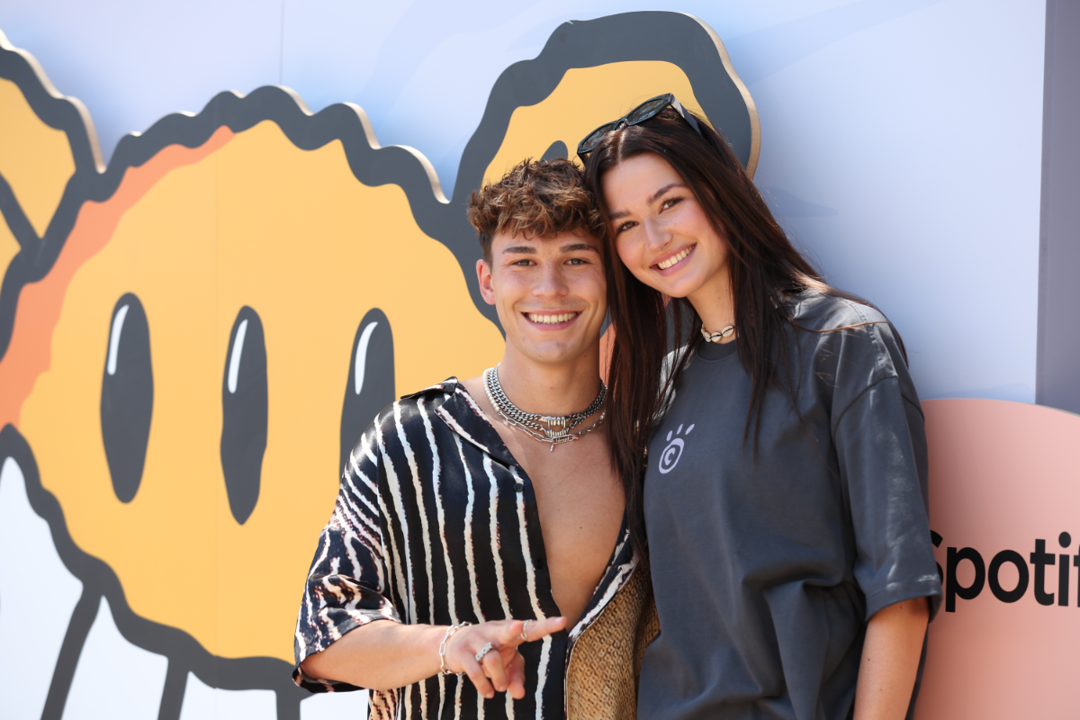 Julien Brown und Angelina Frerk stehend lachend nebeneinander vor einer Wand mit Graffiti