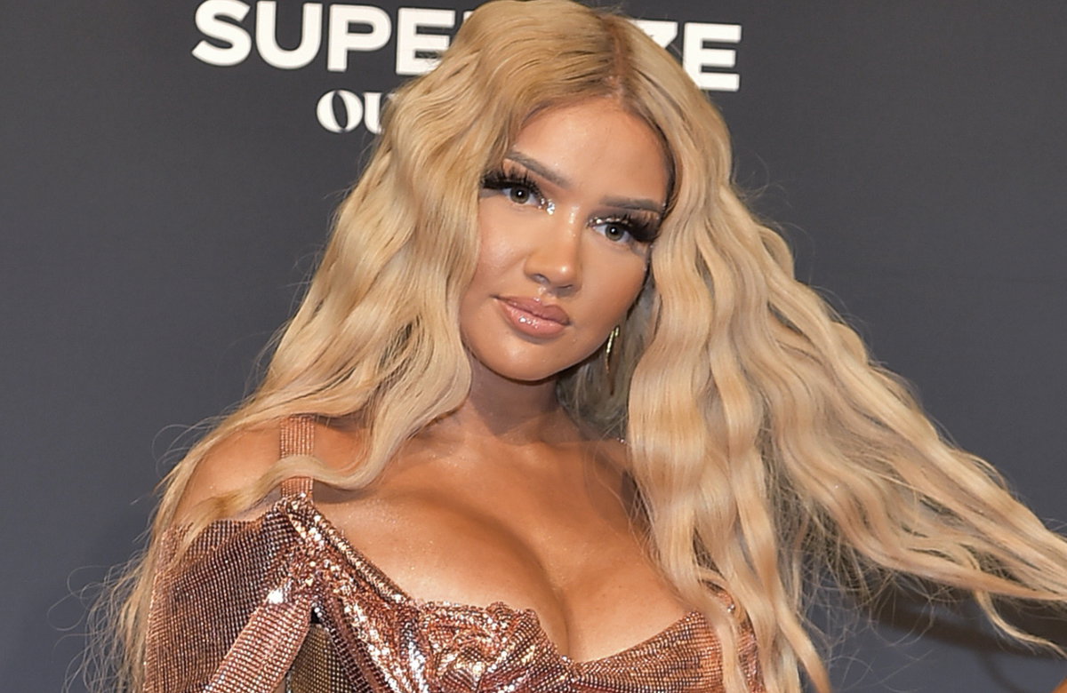 Shirin David fährt sich mit strengem Gesichtsausdruck durch die langen Haare
