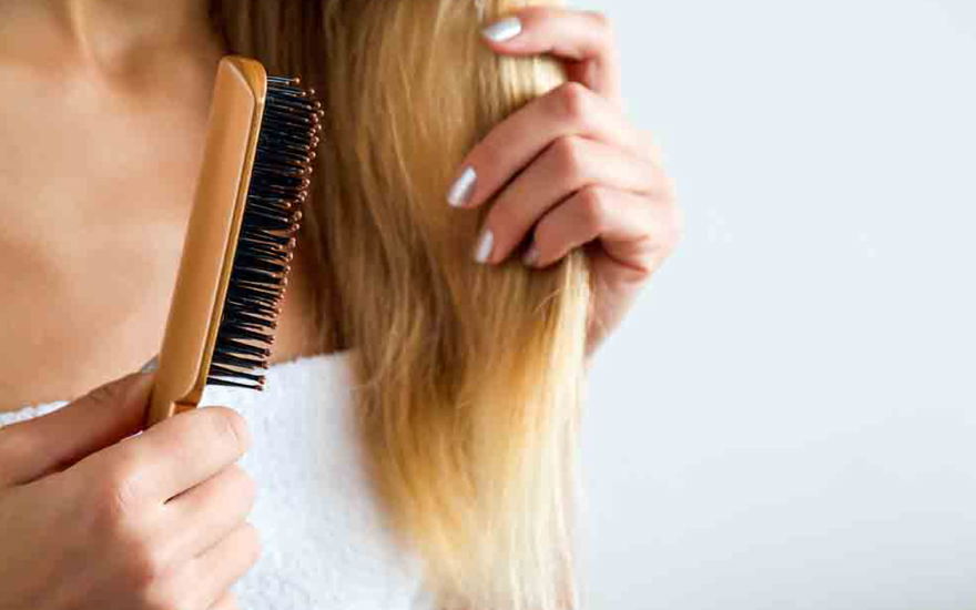 Frau kämmt Haare mit Keratin und Arganöl